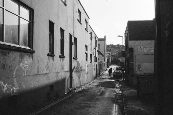 Black and white photo of Hampton lane on a sunny day with a lone sihouletted individual